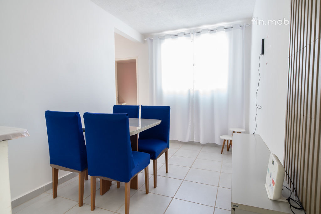 Sala de um apartamento anunciado pela Fin-Mob, com mesa e cadeiras azuis